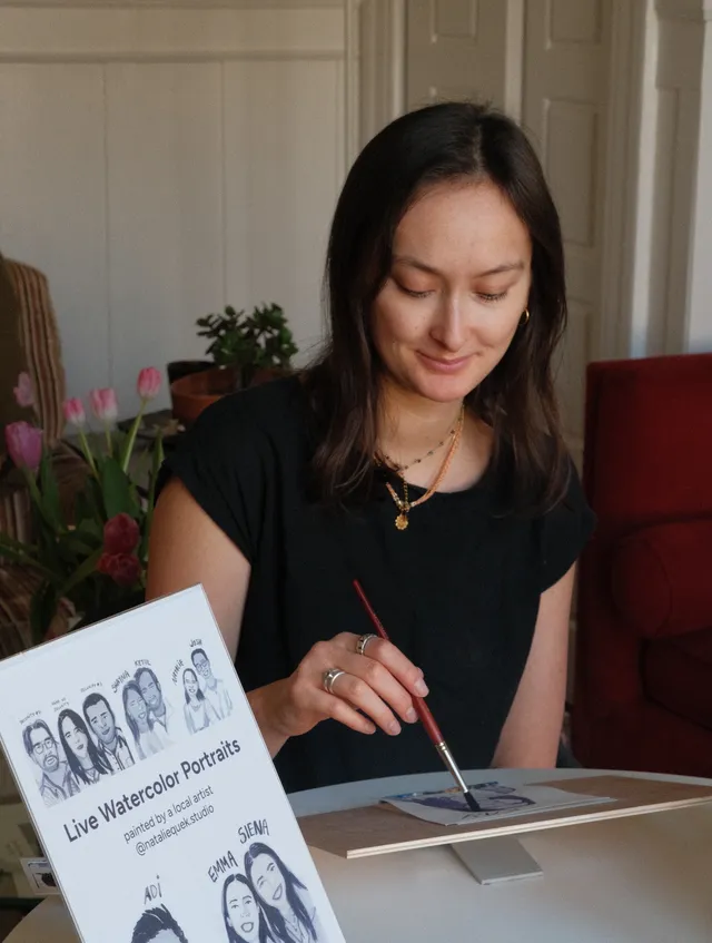 Natalie painting live watercolor portraits at an event