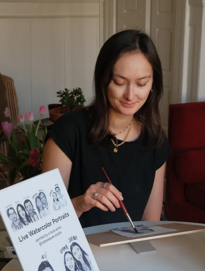 Natalie painting live watercolor portraits at an event