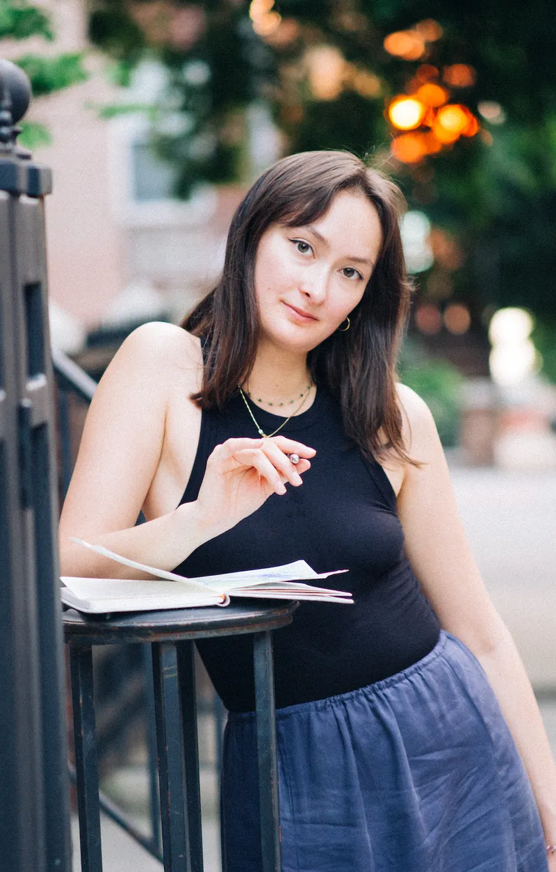 Natalie outdoors with a sketchbook and pen